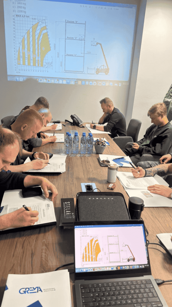 Uczestnicy kursu ładowarek teleskopowych podczas omawiania wykresu udźwigu